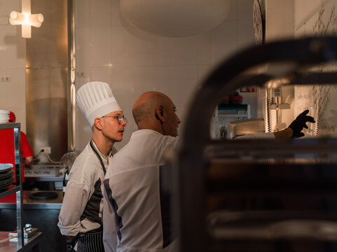 Chef teaching his young colleague 