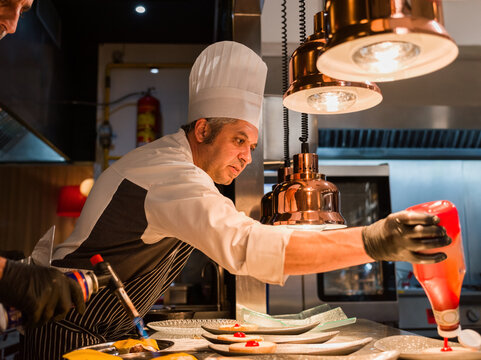 Chef squeezing ketchup on burger 