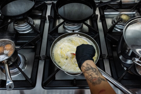 Cook Prepares Dish in Kitchen 