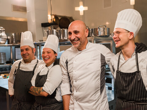 Chefs Smiling Together in Kitchen Environment