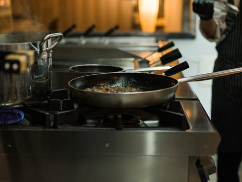 Chef Cooking on a Stovetop in a Modern Kitchen Setting