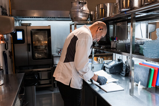 Focused chef reviewing recipes 