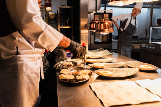Chef burning cheese with torch 