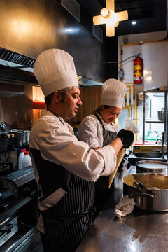 Chefs talking and cooking at kitchen