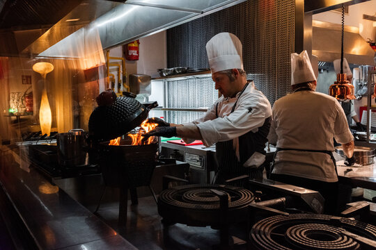 Chef using grill at restaurant kitchen