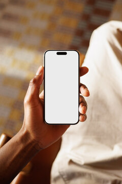 Hand Holding Phone White Screen Mockup in Warm Interior Light