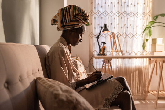 Woman Writing in a Cozy Room With Natural Light in the Afternoon