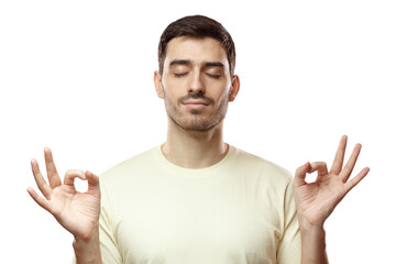 Fototapeta premium Yoga and meditation concept. Concentrated relaxed man standing with closed eyes, having relaxation while meditating, trying to find balance and harmony isolated on pink