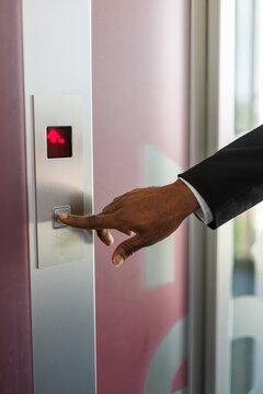 Cropped view of hand of male entrepreneur pushing button in elevator