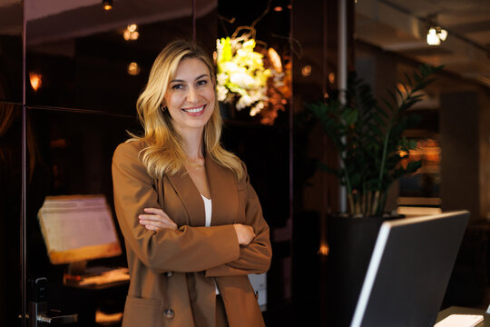 Portrait of female receptionist with crossed arms looking at camera
