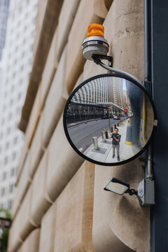 Reflection of a Person in a Street Mirror on a City Street
