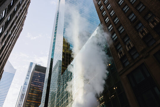 Steam Rises From a Building in a Busy Urban Area in Daylight