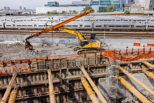 Excavator working at large construction site near rail yard
