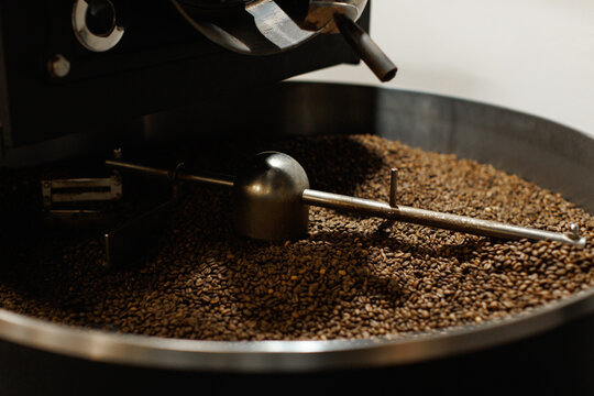 Coffee beans from coffee roaster being poured into cooling cylinder
