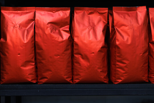 Set of red packages with coffee beans on black background