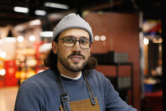 Portrait of young male worker during working at blurred modern factory