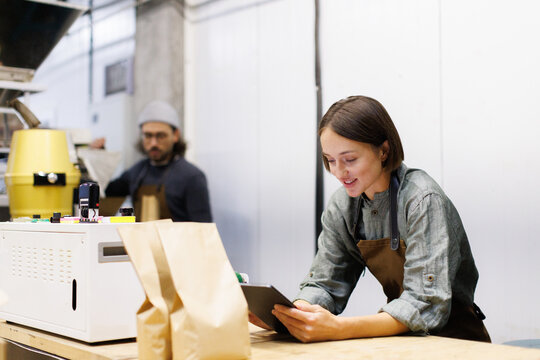 Female worker watching digital tablet near blurred male colleague