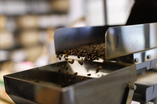 Close up of coffee beans falling out in industrial packing machine
