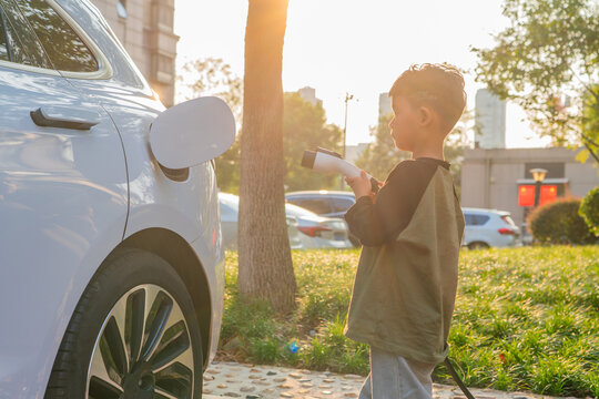 Little Boy Charging Electric Car 
