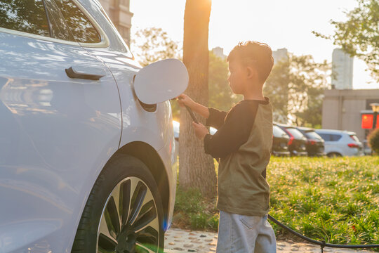 Little Boy Charging Electric Car 
