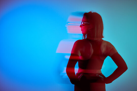 Woman posing in colorful light with motion blur effect