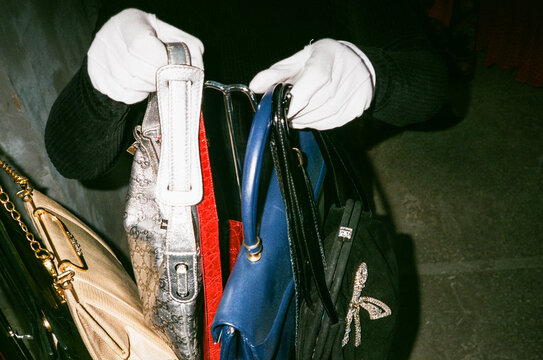 Collection of Handbags held by a Gloved Hand