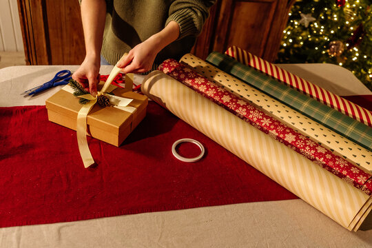 Person Tying Ribbon on Christmas Gift Box 