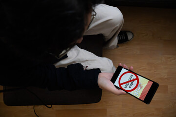 Person Holding Smartphone with Social Media Ban Graphic in Spain