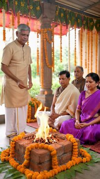 Indian priest performing a sacred Havan fire ritual for a praying family in a decorated courtyard, symbolizing traditional Hindu spirituality.
