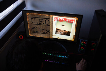 Dark Desktop Setup with RGB Lighting and Secret UFO Investigation Graphic, Extraterrestrial Evidence Featuring Flying Saucer Photo and Disclosure Document