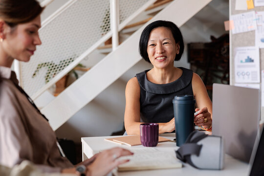 Two women working together at a desk.