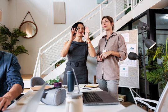 Two women discuss business in a modern office space.