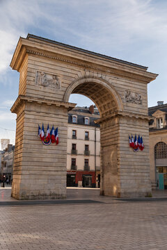 Historical French stone archway with statues an flags on it 