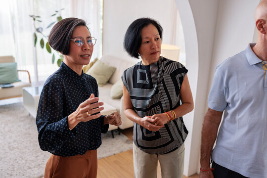 Three people in a living room, one speaking.