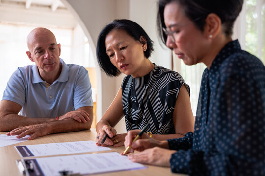 People signing documents at a table.