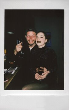 A Polaroid photo of a loving couple with wine at a bar, ugc.