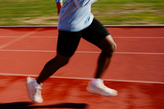 A blur-driven scene reveals an unidentified sprinter rushing down