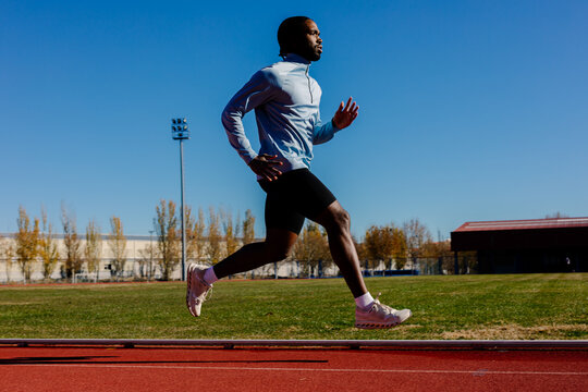 Runner suspended mid-stride, both feet off the track