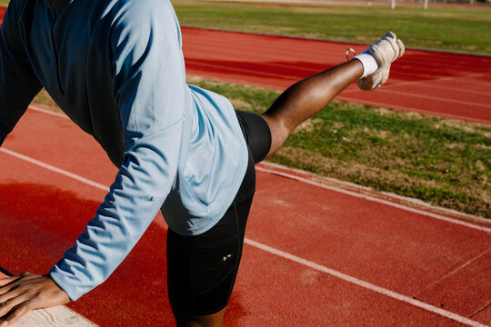 Unknown runner carrying out deliberate stretching movements