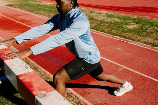 Runner warming up next the track before starting an athletics training
