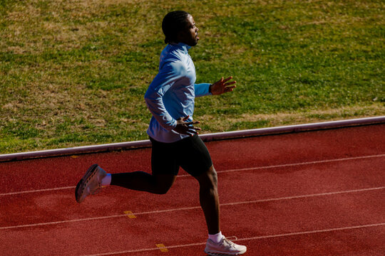 Professional runner sprinting with powerful, extended strides