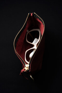 Glimpse of white sunglasses in a letter purse