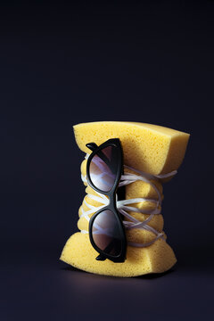 Still life arrangement of black sunglasses tied on a sponge 
