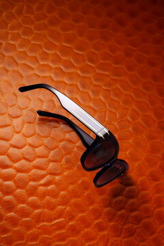 Black sunglasses on textured orange glass