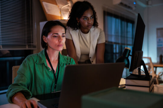 Two women working together at a computer.