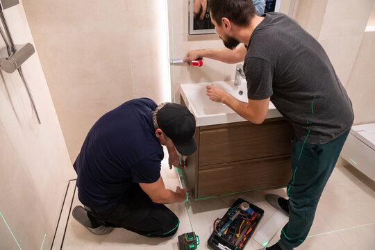 Men Working on Shower Installation With Laser Level