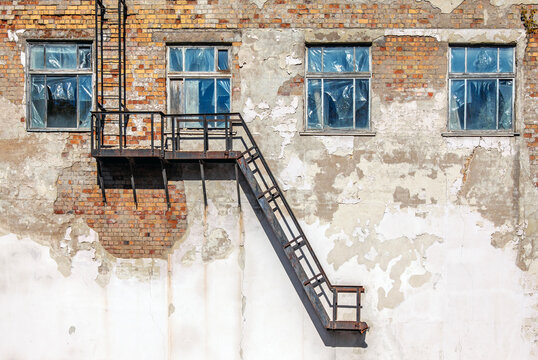 Old abandoned building with staircase and broken windows