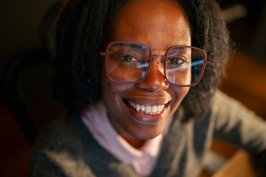 Woman smiling in a cozy indoor space
