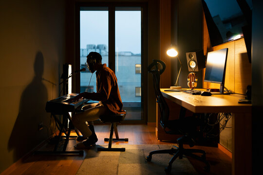 Musician plays keyboard at home
