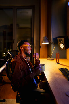 Man enjoying evening at computer desk
